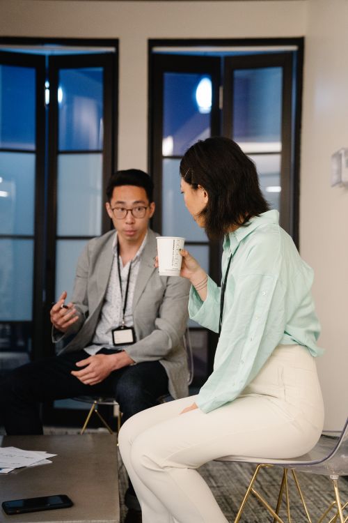 Free Two professionals engaged in a collaborative discussion in a modern office setting. Stock Photo