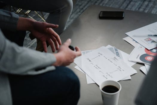 Close-up of a business meeting table with notes, documents, and a coffee cup.