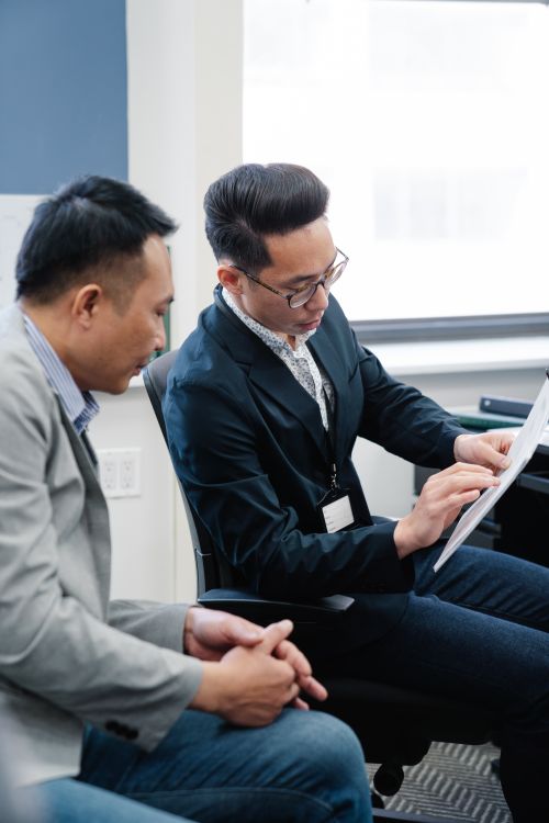 Free Two professionals engaged in a collaborative discussion at the office. Perfect for corporate themes. Stock Photo