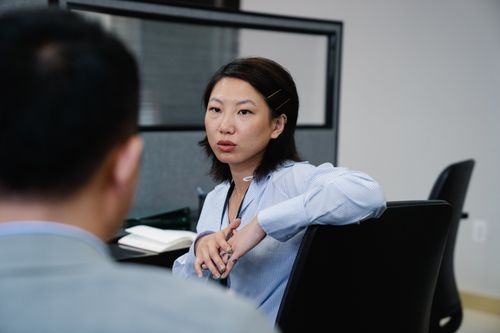 Free Professional woman having a focused discussion in an office setting. Business attire and collaborative environment. Stock Photo