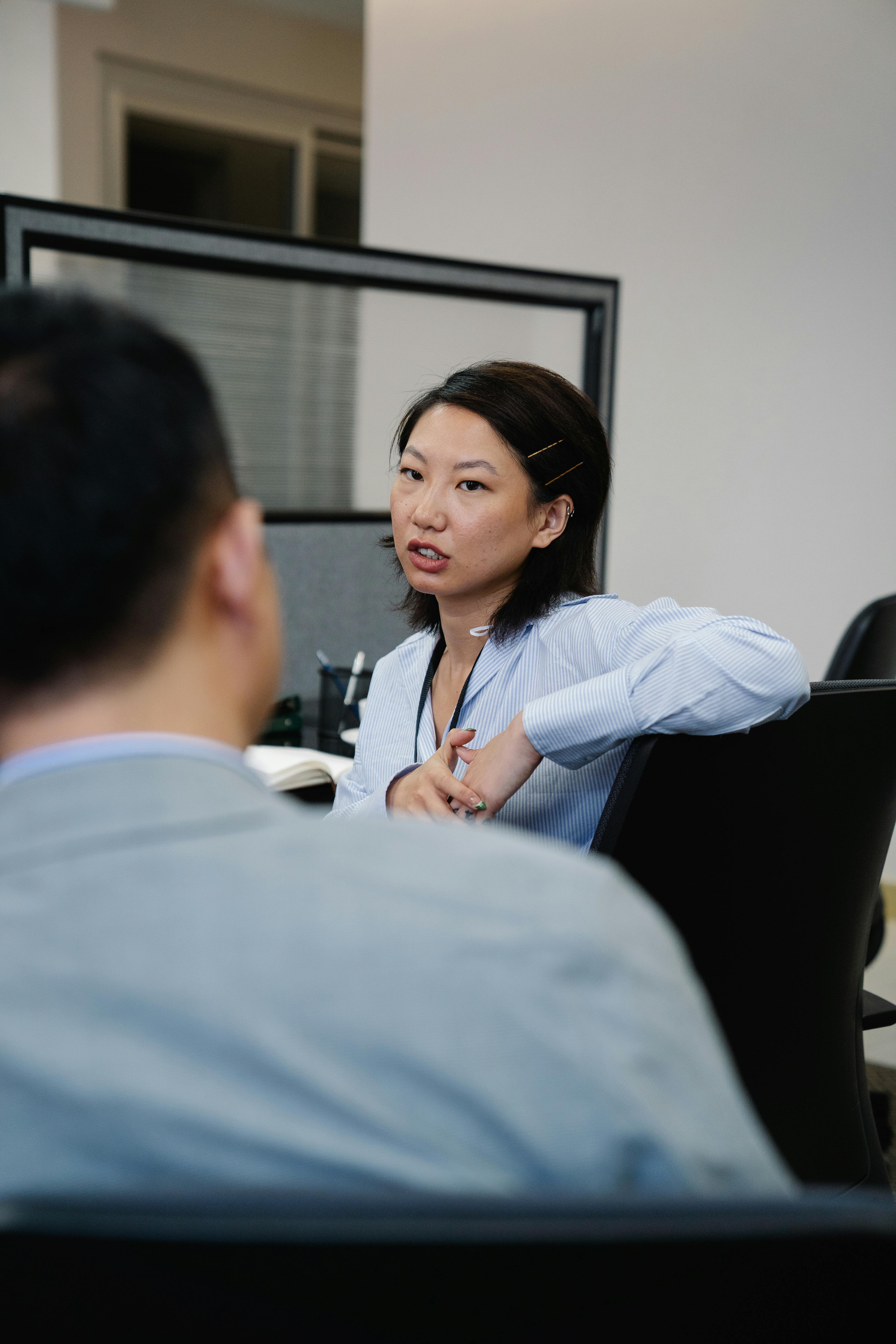 Two professionals engaged in an office discussion, focusing on teamwork and communication.