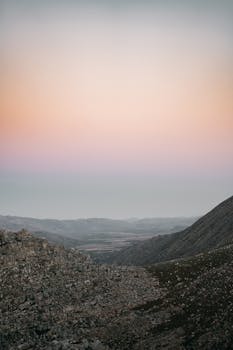 Serene mountain landscape with pastel sky colors at dusk, capturing natural beauty and tranquility.