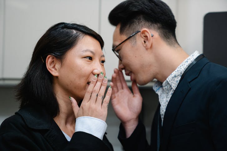 Photo of a Man Telling a Secret to a Woman