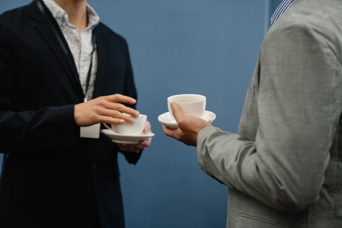 Two professionals chatting over coffee cups
