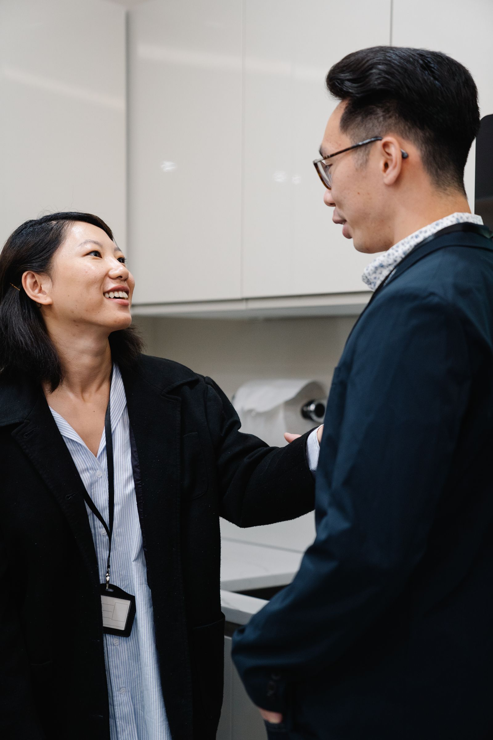 Two Asian adults having a supportive conversation in a quiet workplace