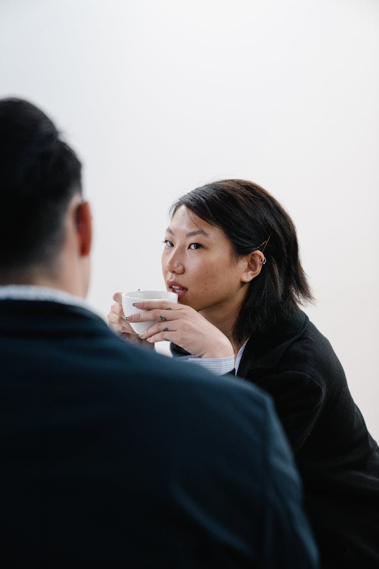 Woman Drinking Coffee During Business Meeting