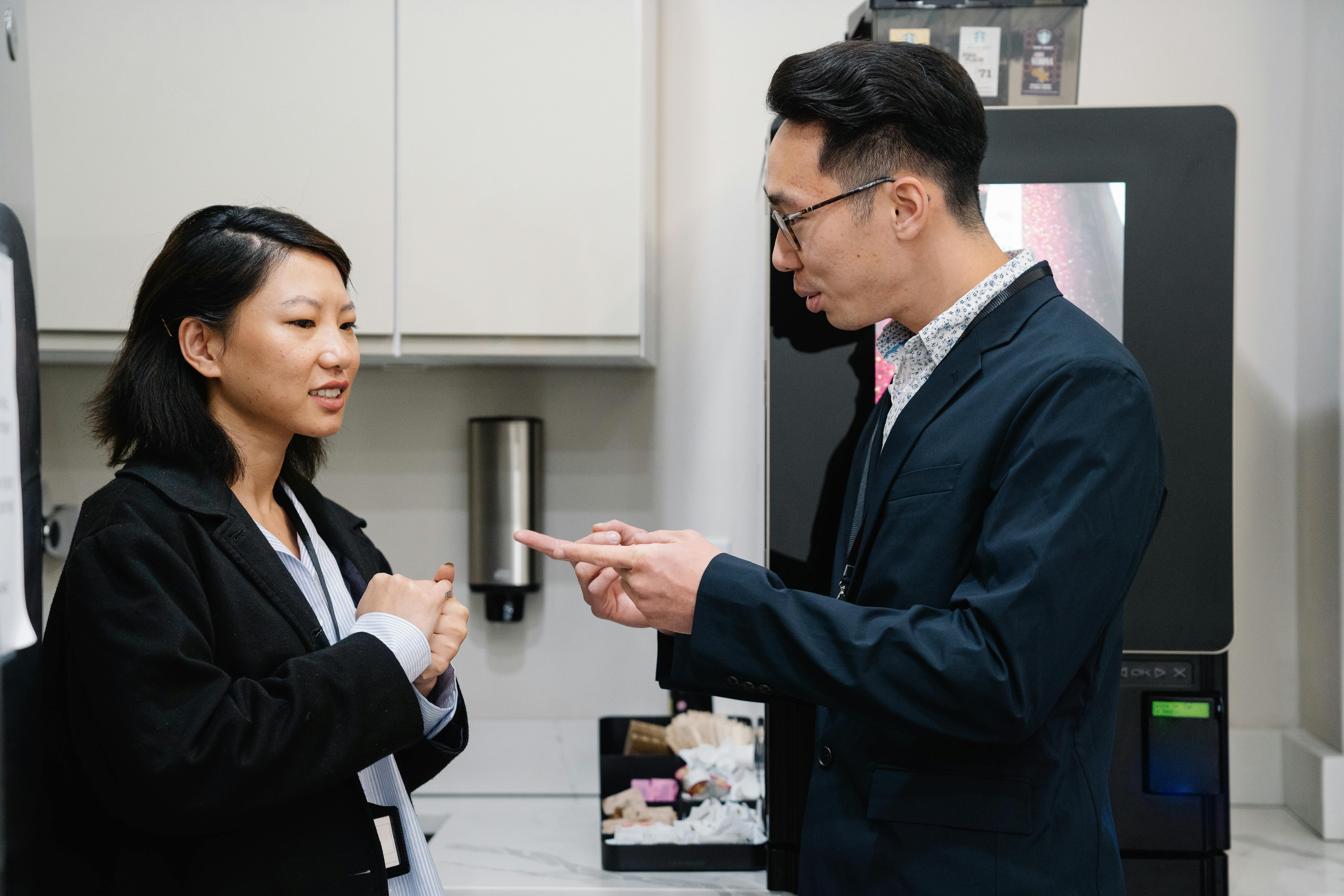 Một người đàn ông và một người phụ nữ đang nói chuyện trong bếp văn phòng.