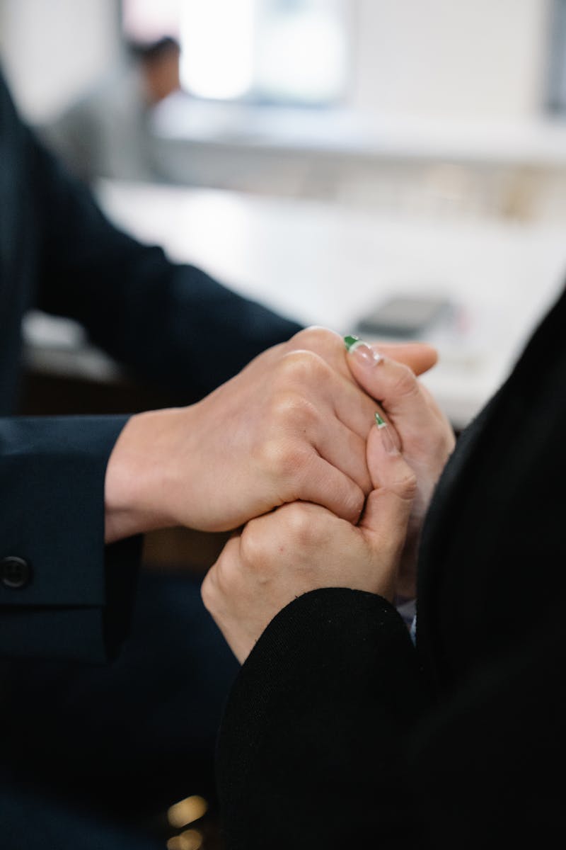 Close-up of supportive hand-holding during recovery