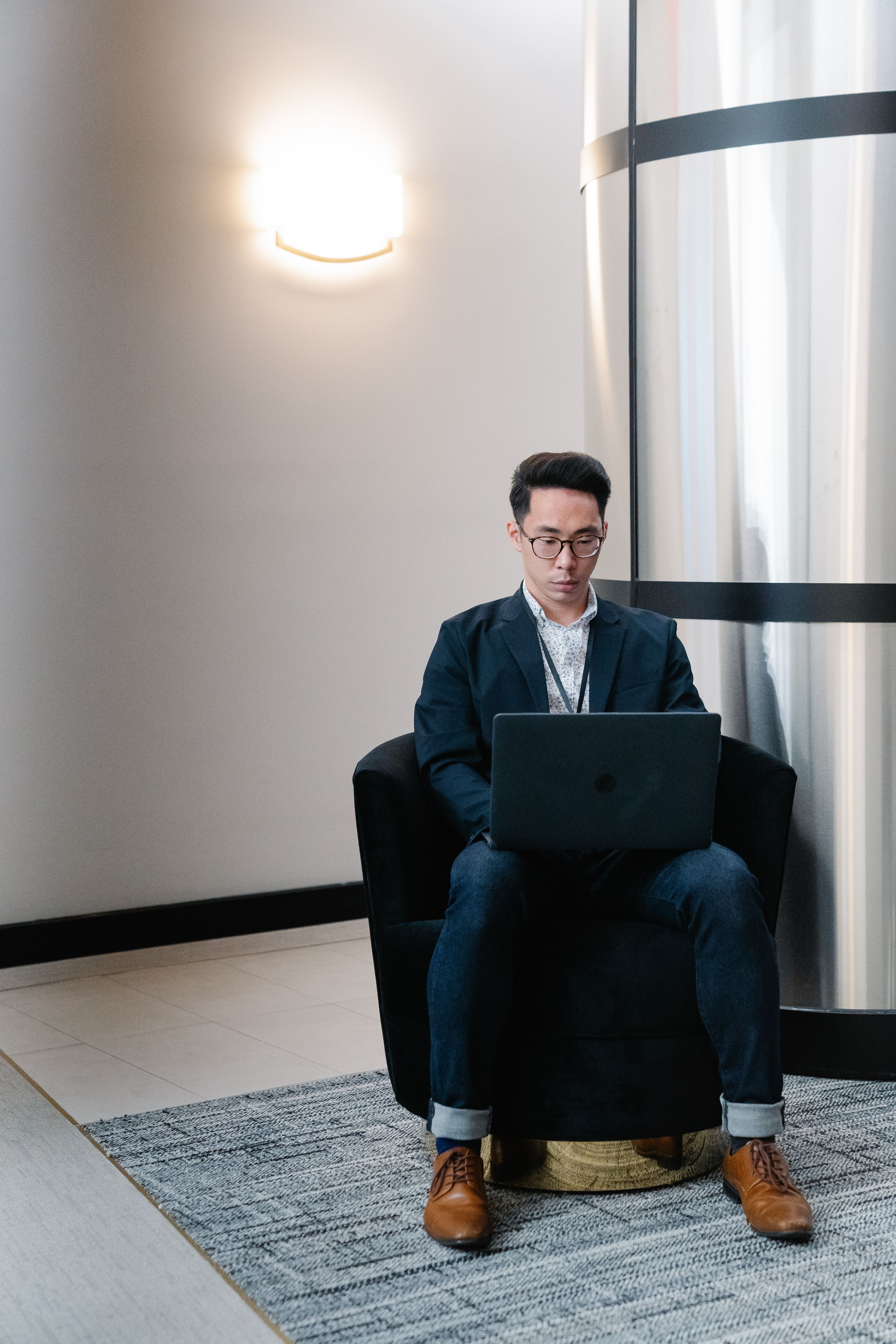 elegant man sitting in an armchair using laptop