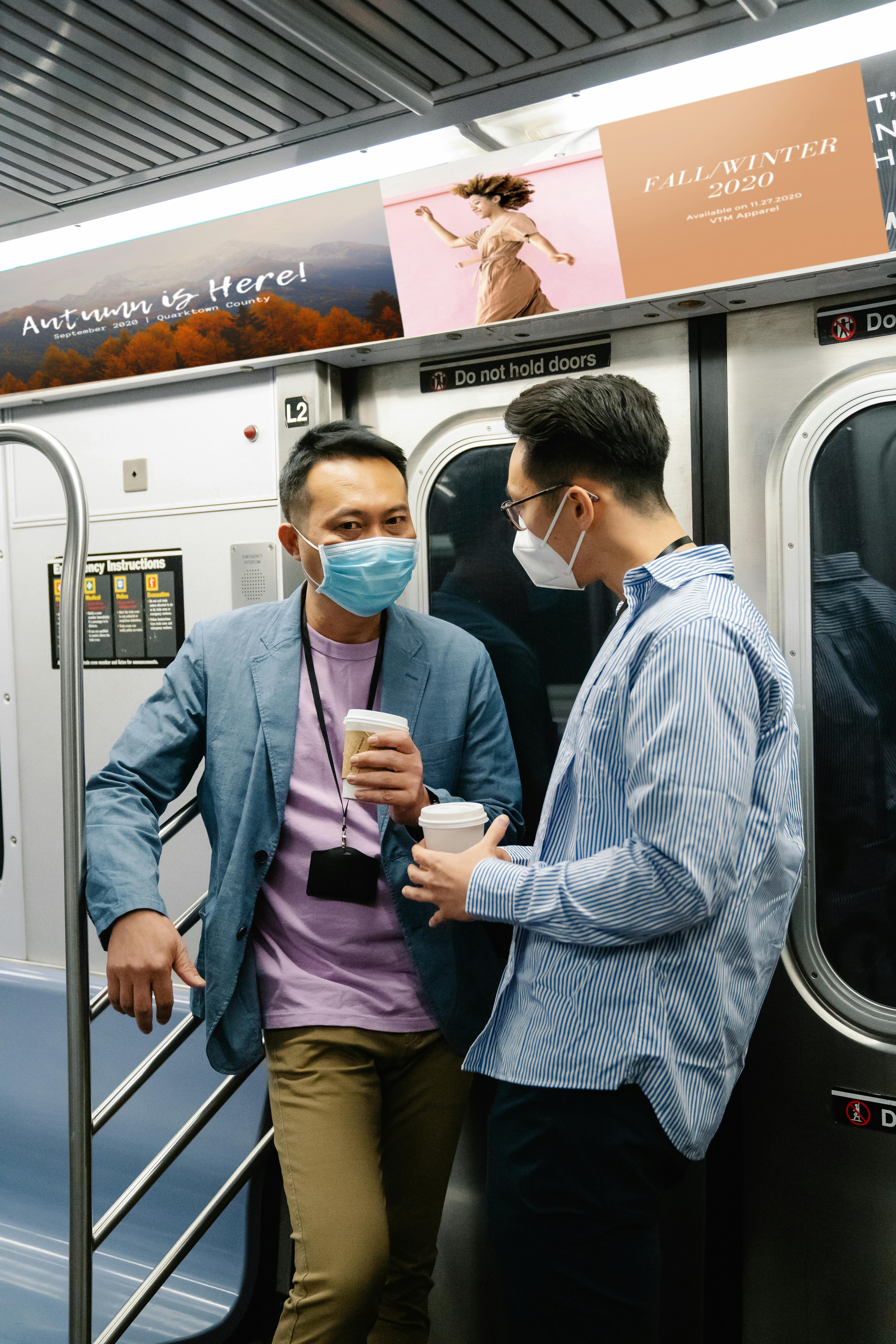 man men holding cup of coffee inside a train