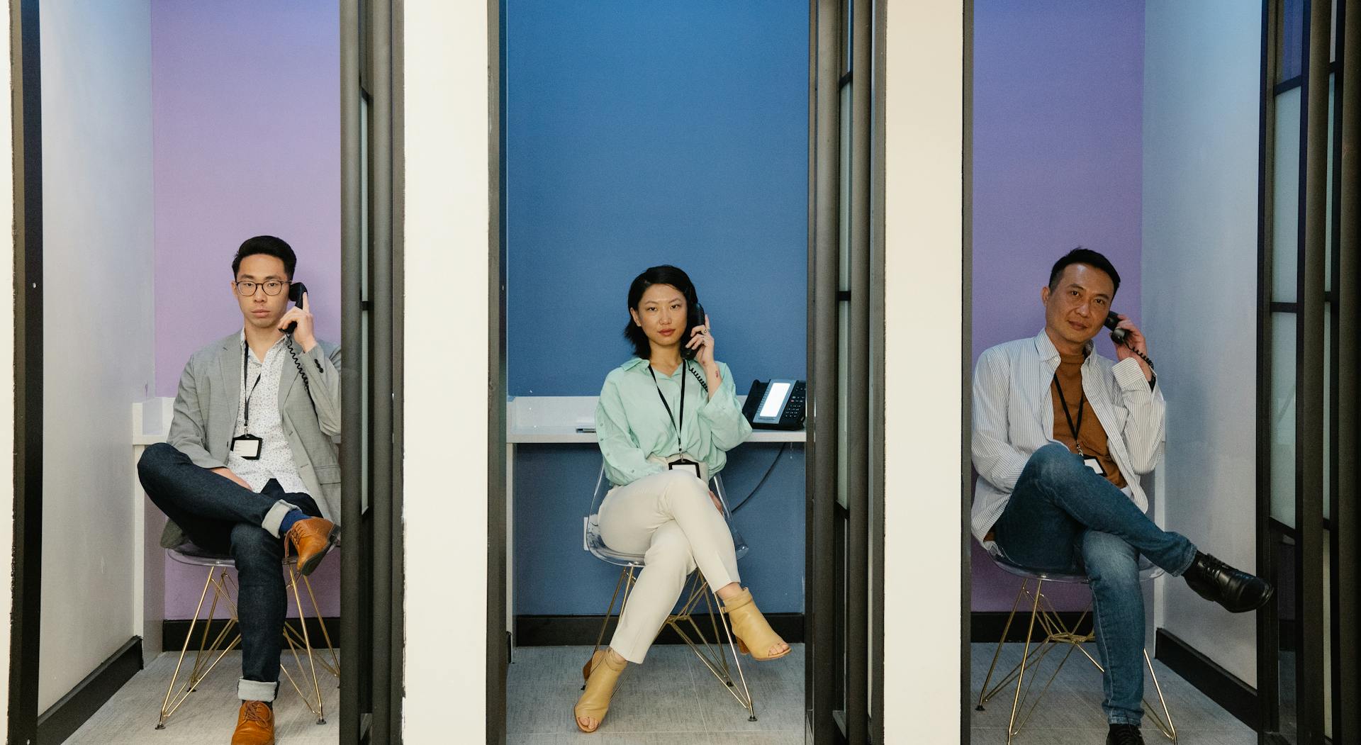 Three professionals working in modern call booths, maintaining communication efficiency.