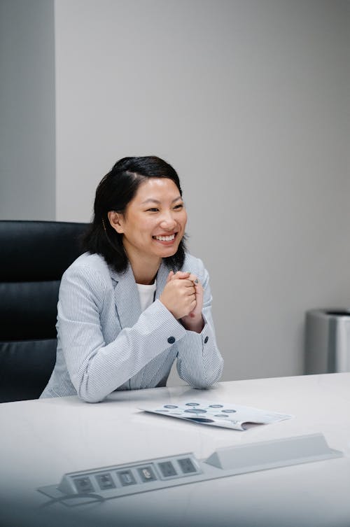 Woman in Gray Blazer Sitting on Black Office Chair