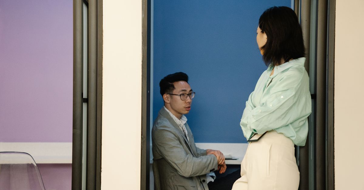 Two colleagues engaging in a conversation in a stylish and modern office setting.
