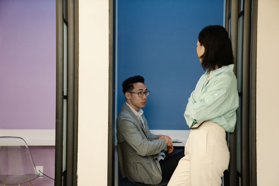 Two people in a work conversation in a bright office