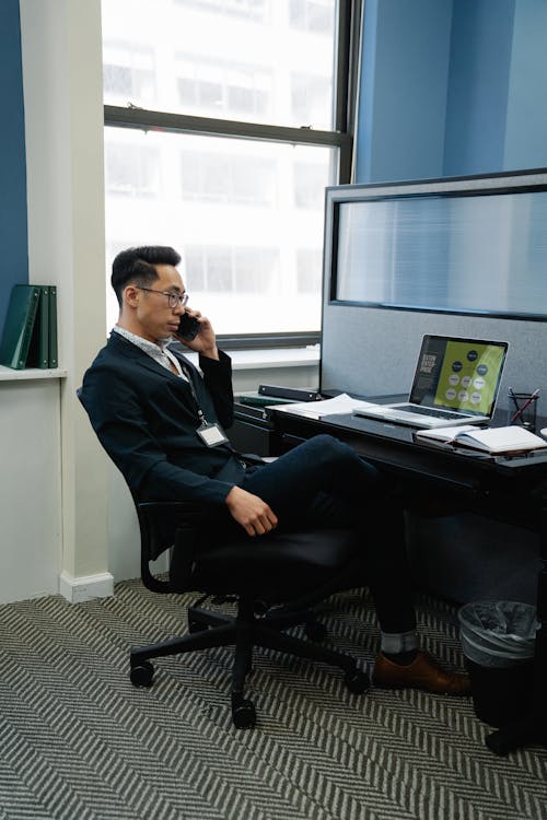 Free Man in Black Suit Talking on the Phone Inside an Office Stock Photo