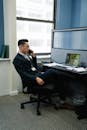 Man in Black Suit Talking on the Phone Inside an Office