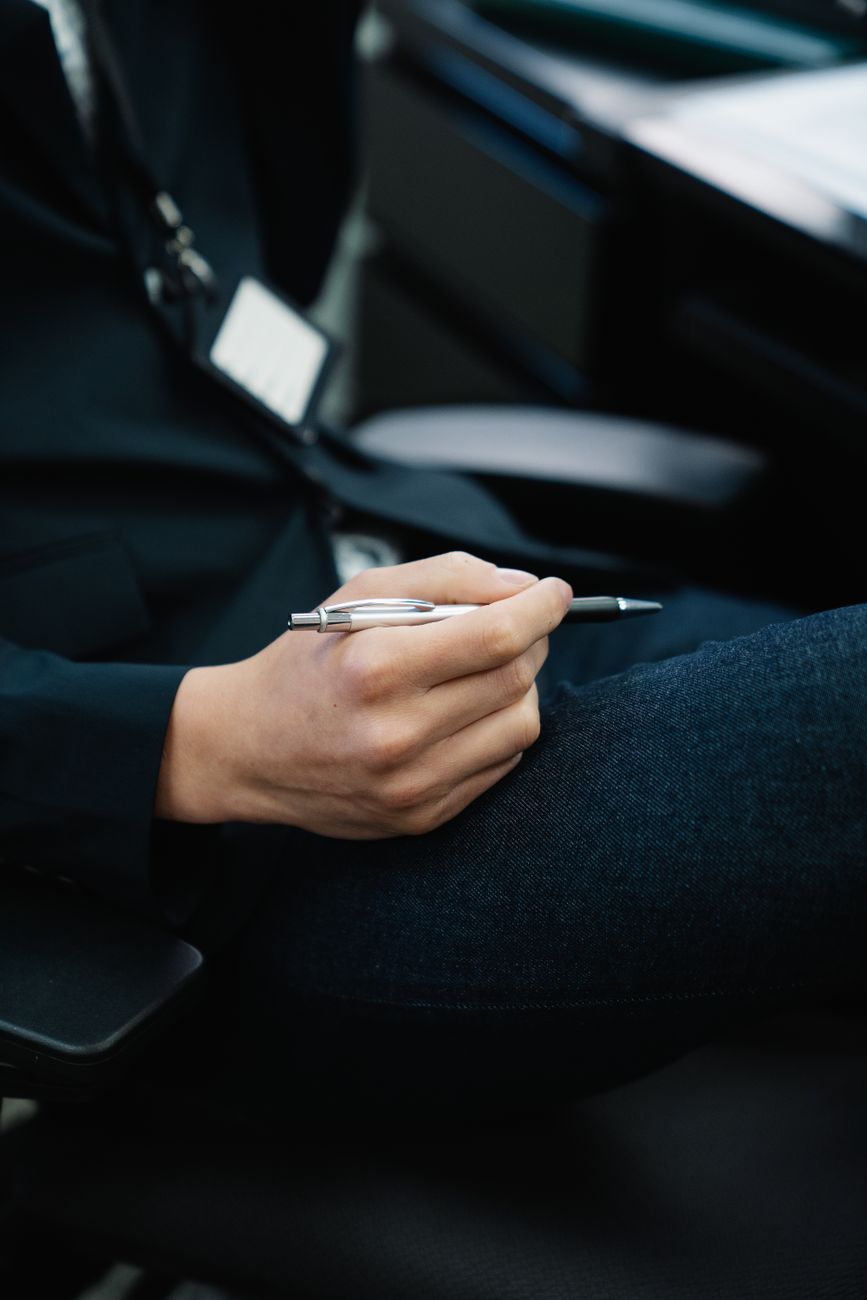 Close-up of a hand holding a silver pen, ideal for business contexts