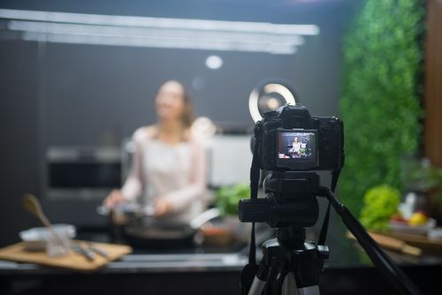 Free Behind the scenes of a cooking show setup with camera and tripod capturing the chef. Stock Photo
