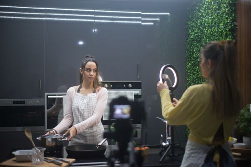 Free Two women creating a cooking video in a stylish kitchen setup with ring light. Stock Photo