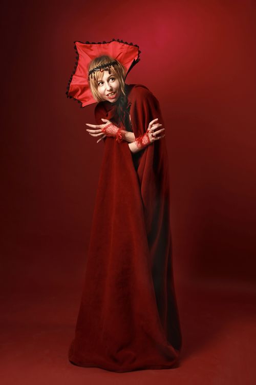 Free A woman in an elaborate vampire costume poses in a dramatic Halloween-themed photo. Stock Photo