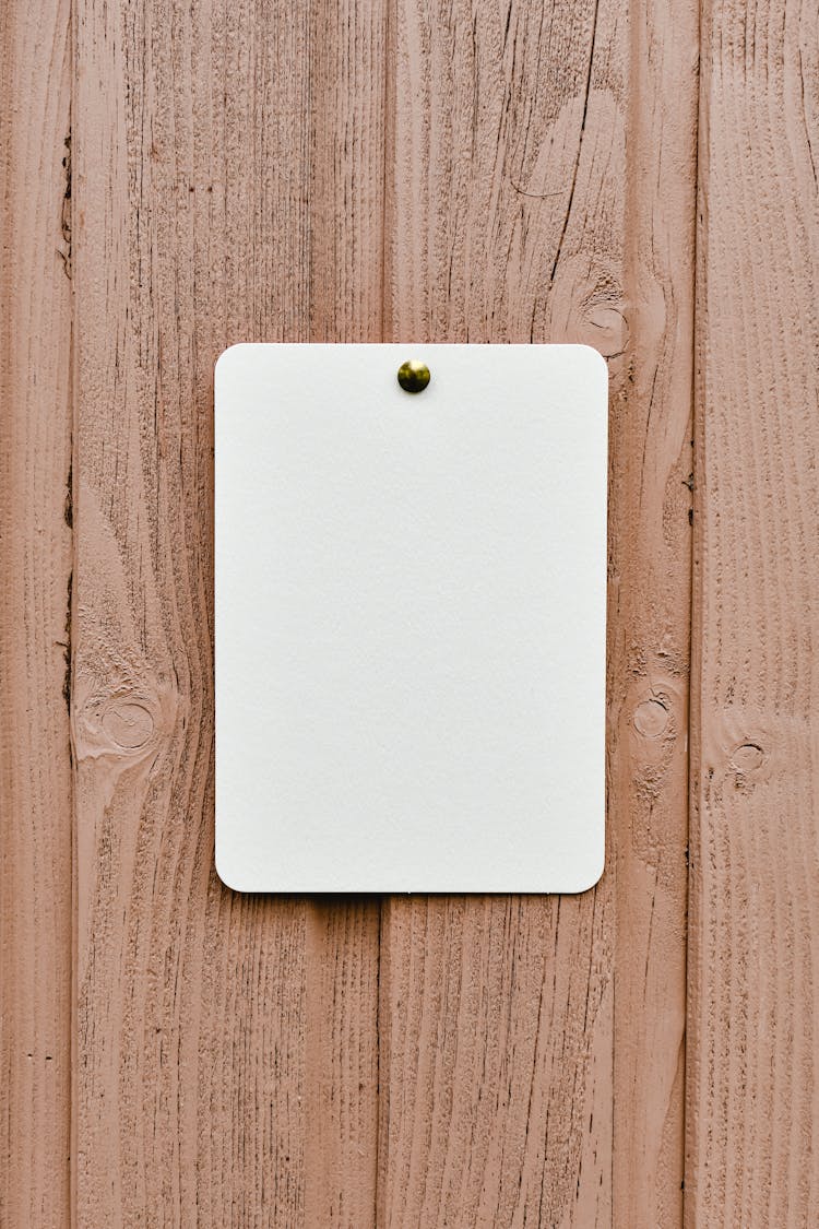 A White Paper Pinned On The Wooden Wall