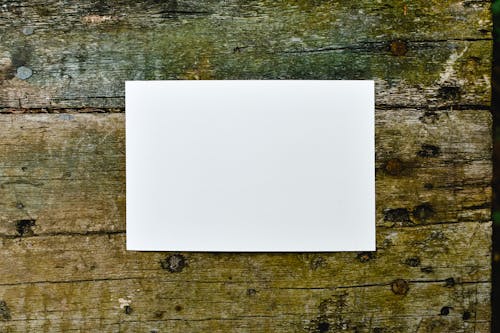 White Paper on Brown Wooden Surface