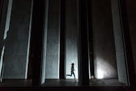 在充满戏剧性灯光的城市环境中，一个人奔跑的动态轮廓