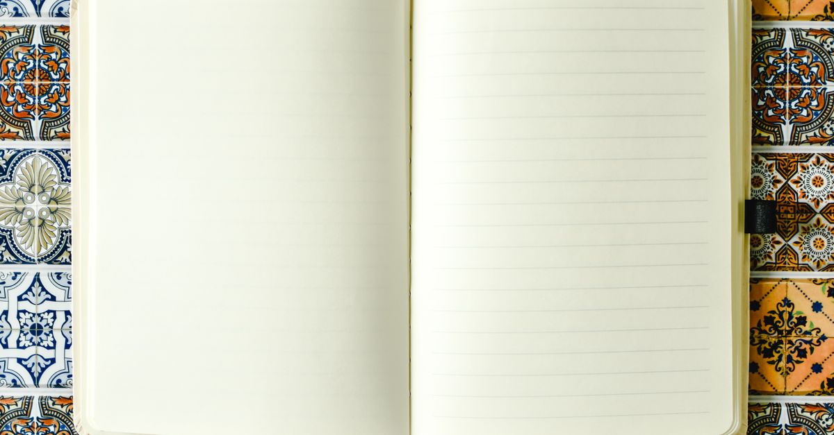 Caderno pautado em branco sobre um fundo vibrante de azulejos, perfeito para uso criativo.