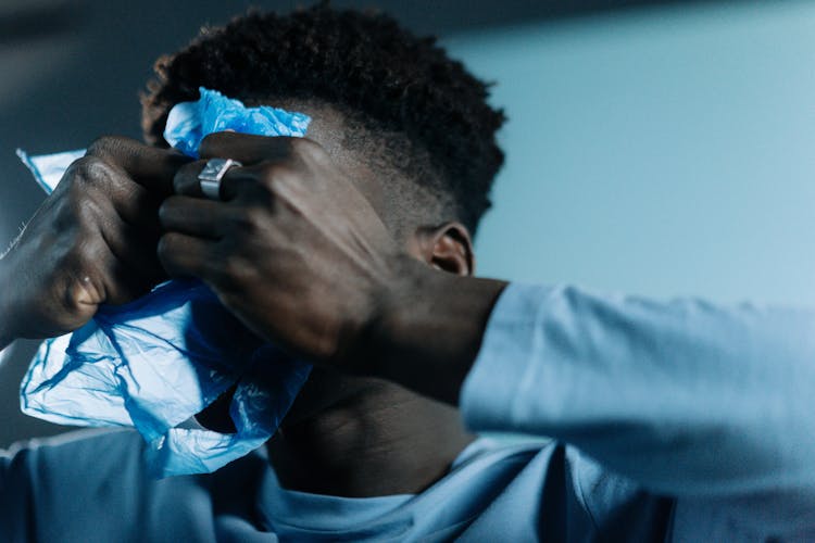 A Man In Blue Long Sleeves Holding Plastic