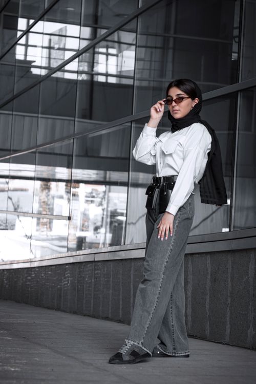 Free Fashionable woman poses in Tehran, Iran wearing sunglasses and chic attire on an urban street. Stock Photo