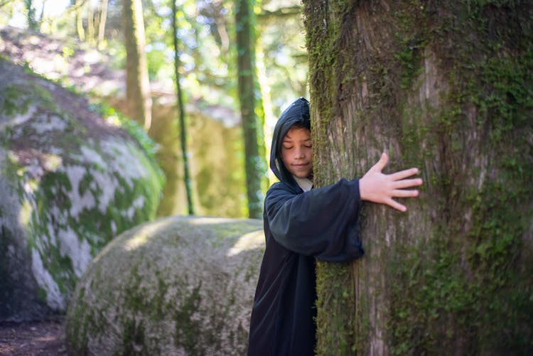 A Boy Hugging The Tree