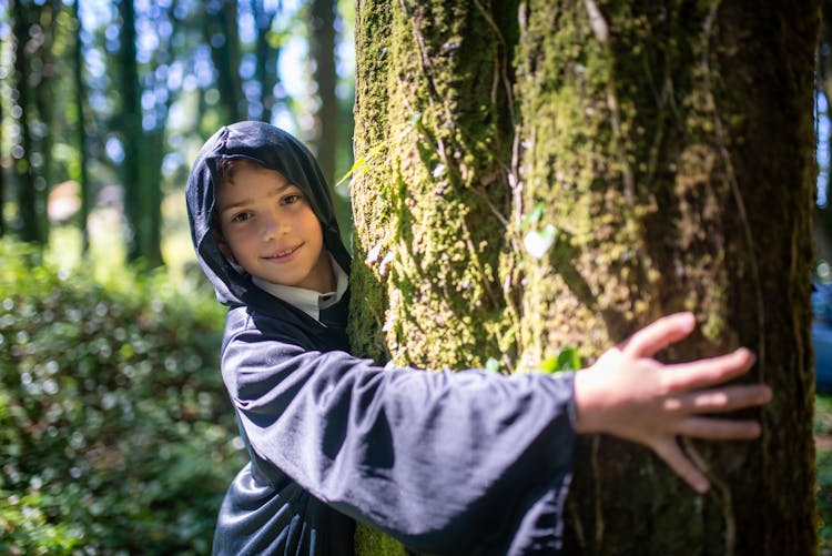 A Boy Hugging The Tree