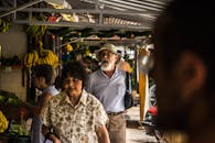 热闹的户外市场里，人们在色彩缤纷的摊位间选购新鲜水果