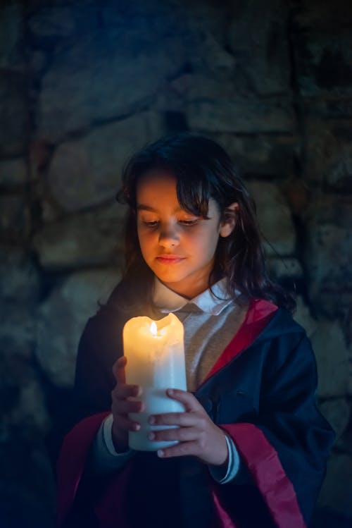 Free Girl in Black Cape Holding Lighted Candle Stock Photo