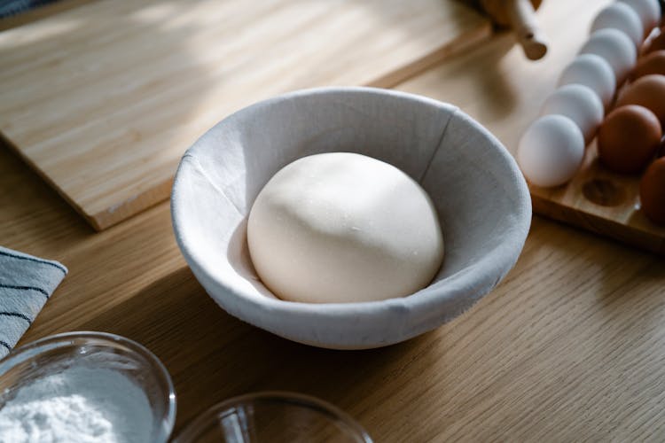 Close-up Of A Dough Growing In A Bowl On A Kitchen Counter 