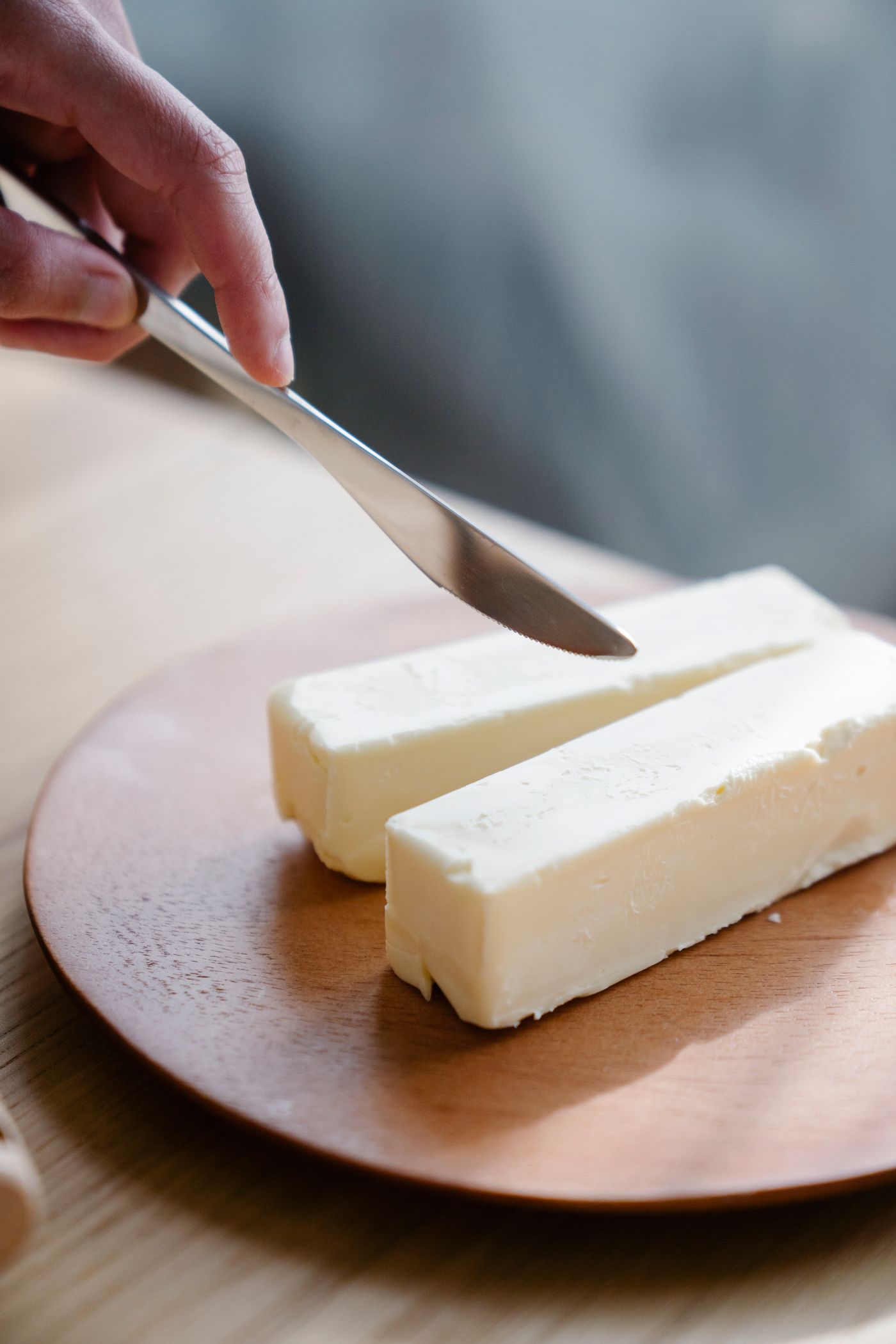 Butter stick being cut into a measured portion with a knife