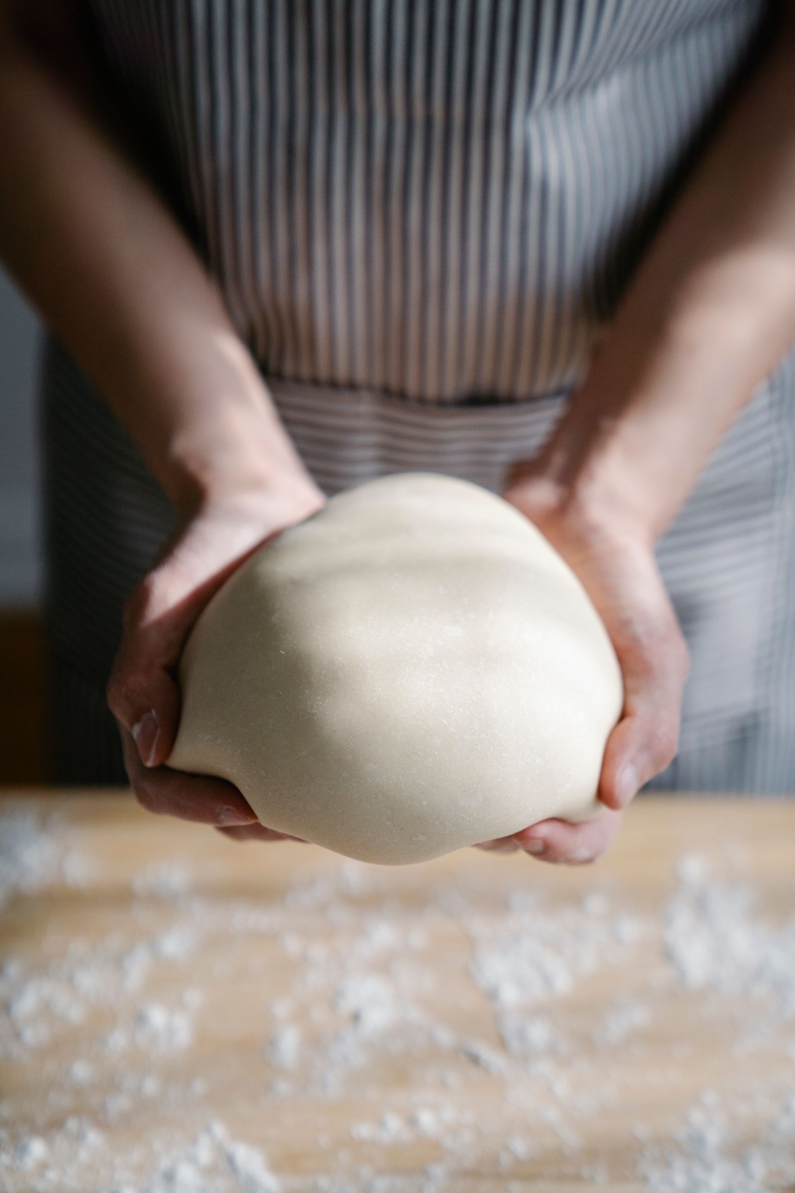 Baker kneading bread dough before adding recipe-specified butter
