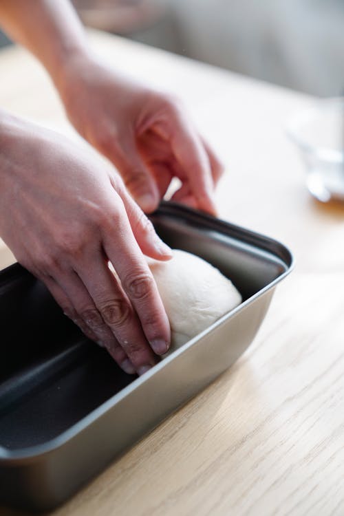 Free Person Putting Dough in a Tray Stock Photo