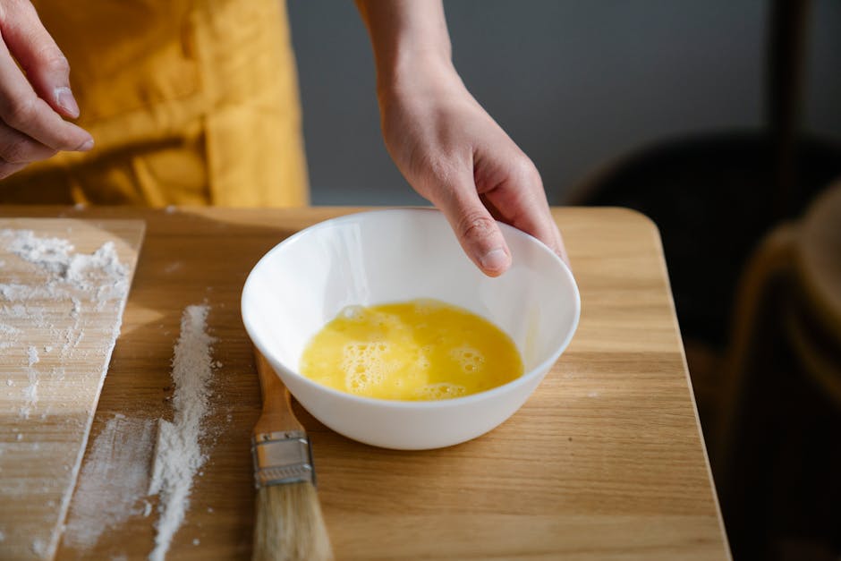 Close-up of eggs being prepared in a bowl for baking in a kitchen.