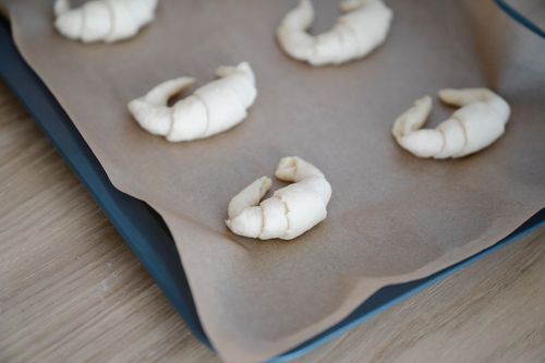 Free Fresh homemade croissants ready to bake on parchment paper lined tray. Stock Photo
