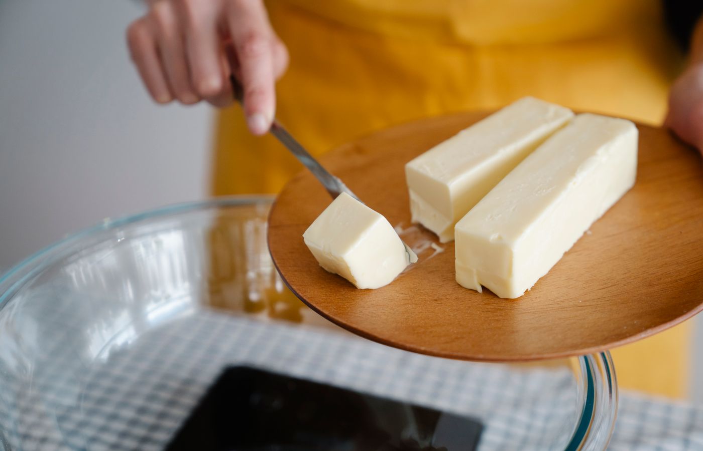Focused shot of cutting butter for meal preparation, essential cooking ingredient.