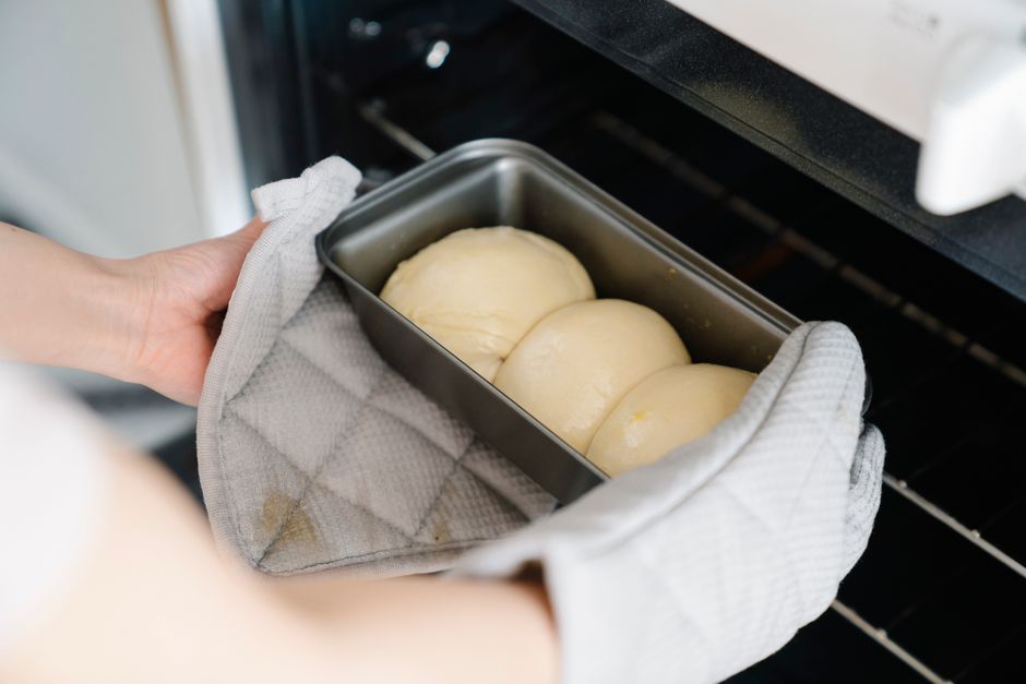Shaped bread dough proofing in a banneton basket inside an oven