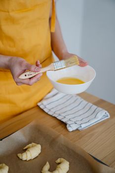Man Basting Croissants before Baking 