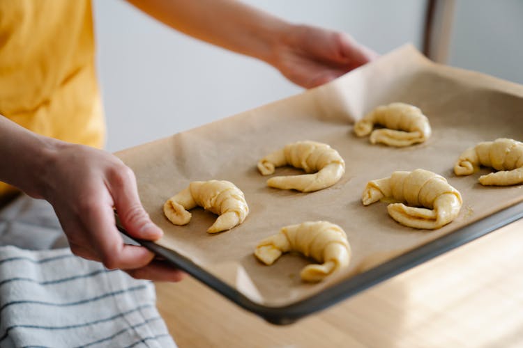 Man Holding Baking Sheet With Raw Criossants