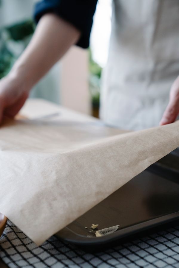 Greaseproof paper sheet being placed on a tray