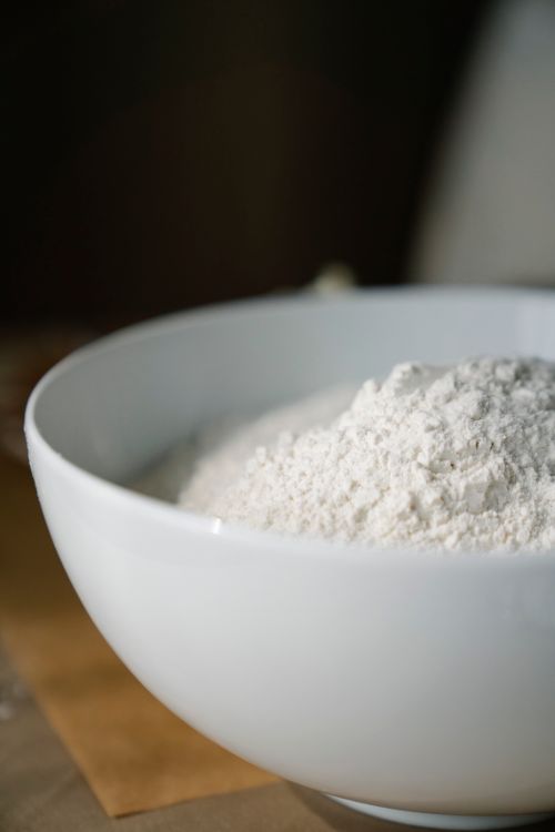Free A detailed close-up of flour in a white bowl, perfect for baking and cooking themes. Stock Photo