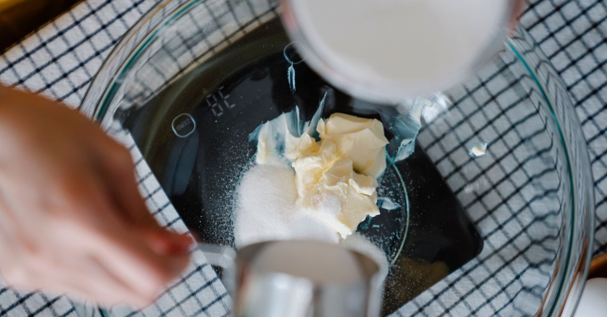 close-up of hands using a digital scale and refractometer over a bowl of chili