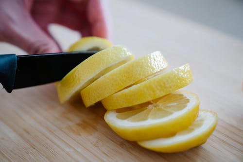 Sliced Lemon on Brown Wooden Surface
