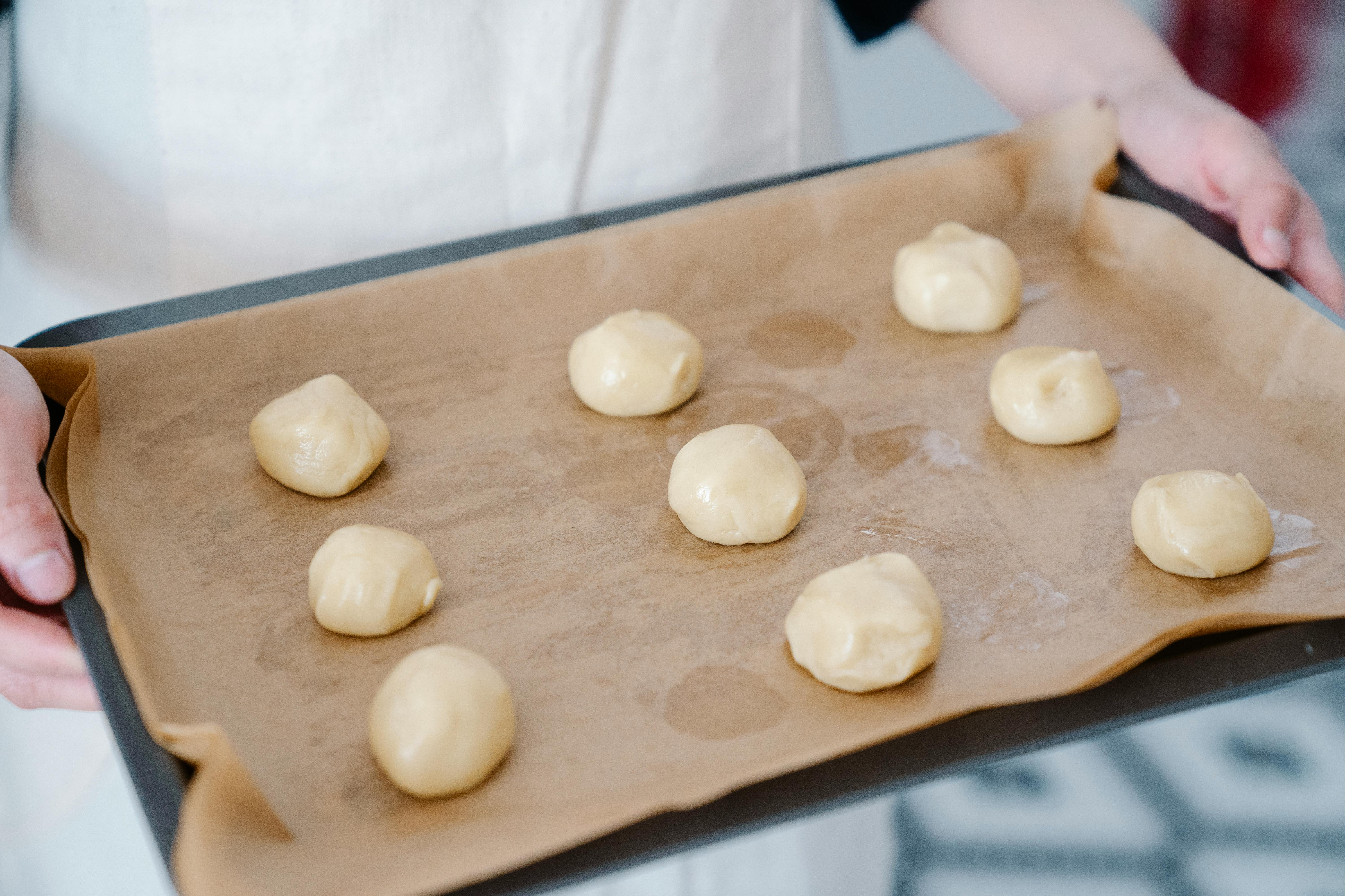 rounded dough over baking paper in a baking pan