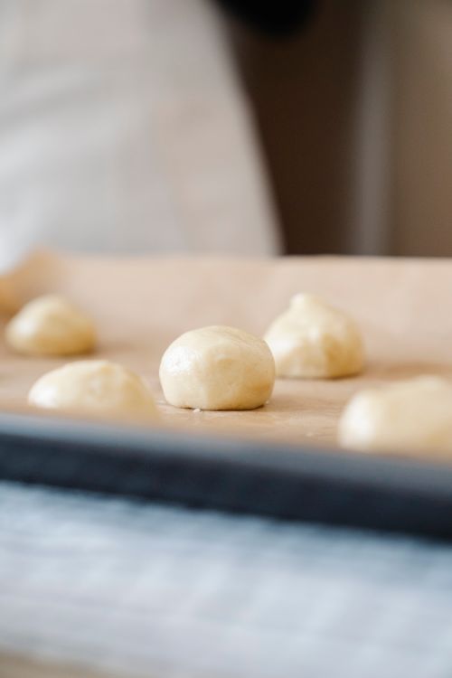 Free Fresh dough balls on a baking tray, ready for baking. Soft focus image. Stock Photo